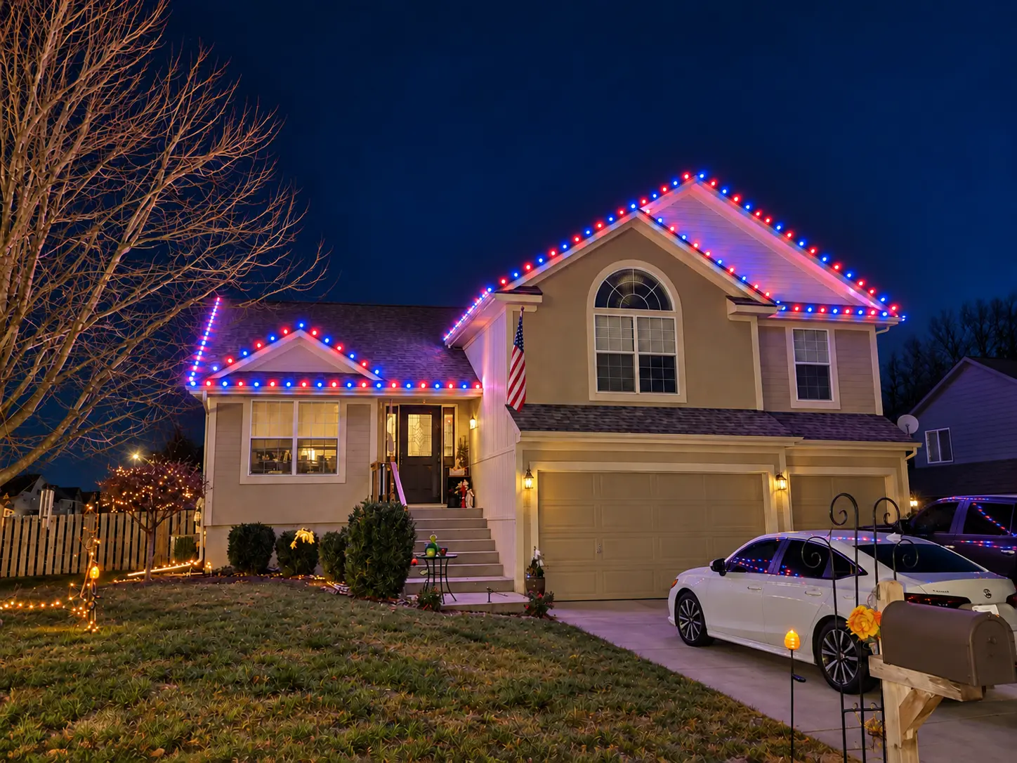 Two-story home outlined with red and blue Christmas lights