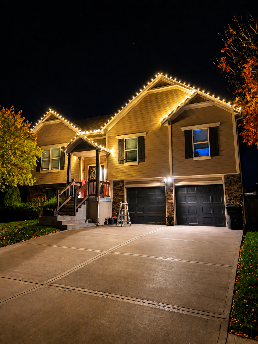 Two-story home outlined with warm white Christmas lights
