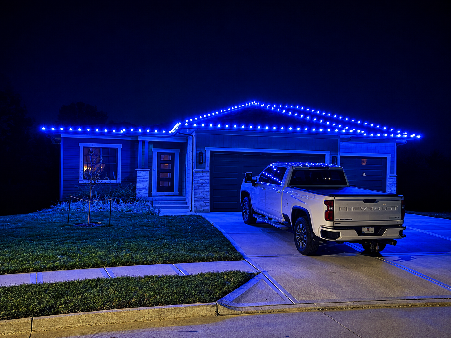 Ranch home outlined in bright blue Christmas lights